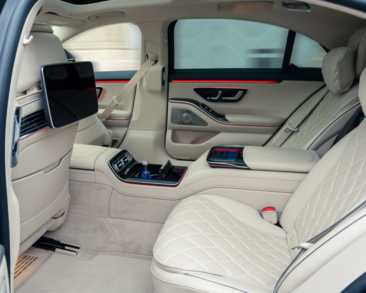 Chauffeur in professional attire opening a car door in Copenhagen.