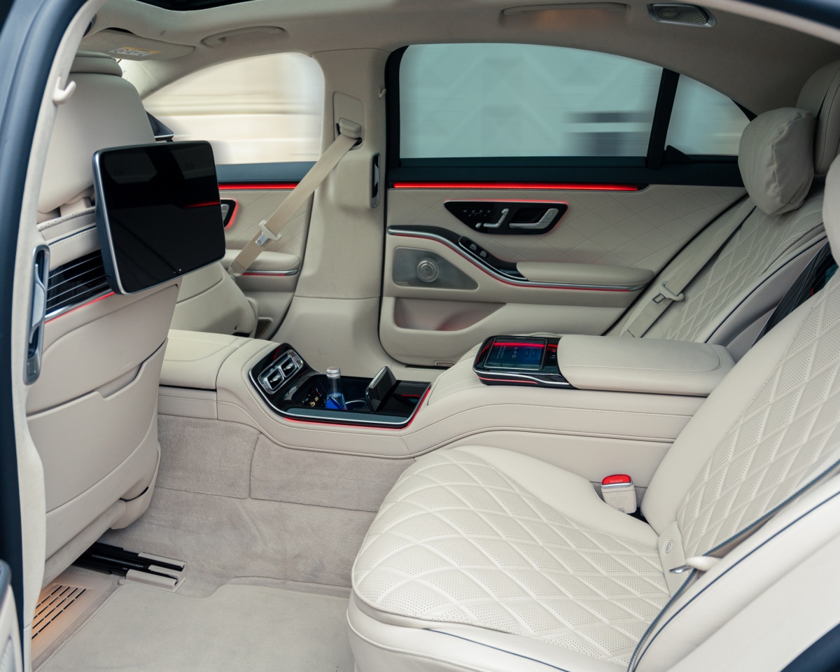 Chauffeur in professional attire opening a car door in Copenhagen.